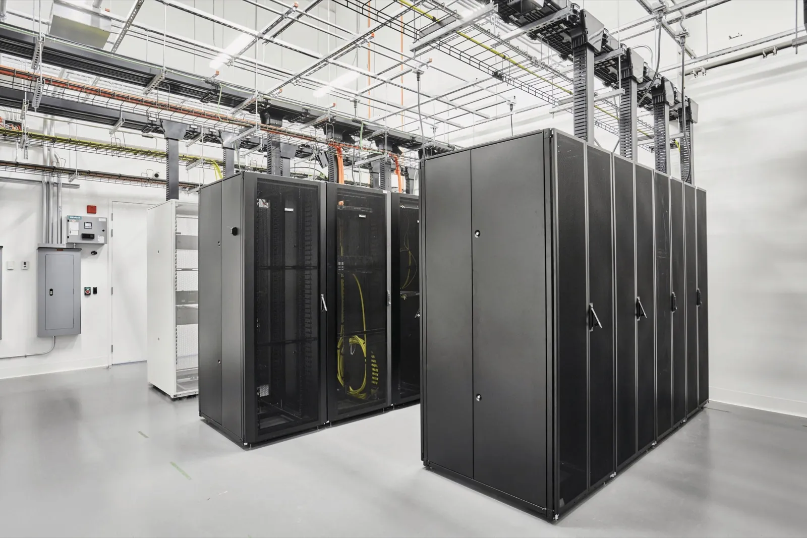 Rows of locked server cabinets with overhead cable trays